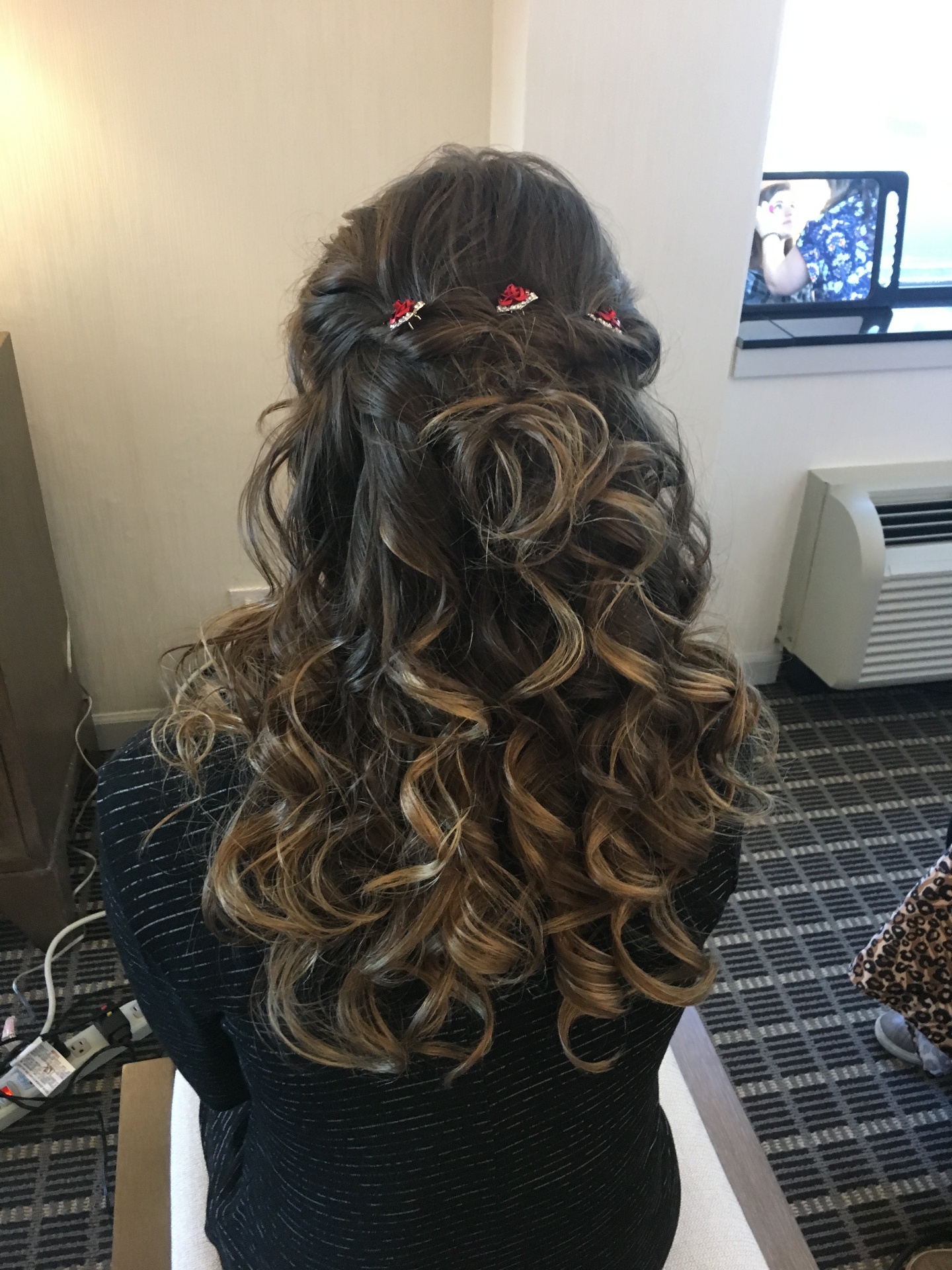 Half-up bridal curls with red floral pins
